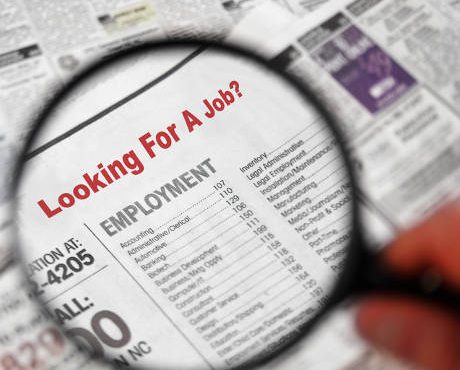 Magnifying glass over Jobs section of newspaper classifieds