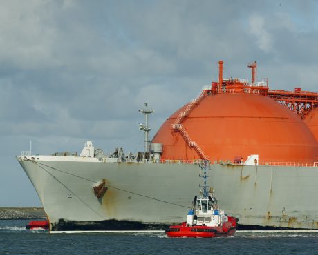 Gas tanker entering harbour with help of tug boat